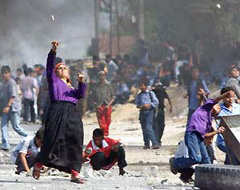 Woman and young boys throwing stones in Kfar Darom - photo from Arabia.com