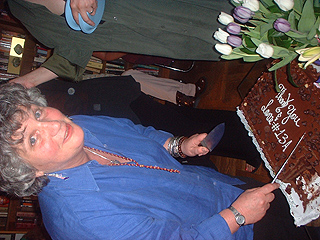 Joan Cutting Cake with frosting that says 'Thank You & Love #13A'