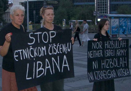 Women in Black holding sign that says 'STOP ETNICKOM CISCENJU LIBANA' tr: 'Stop Ethnic Cleansing of Lebanon'